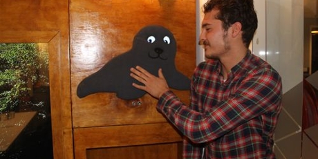 Former student Ziya touches a seal from textile on the interactive wall