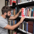 Student takes book from shelve