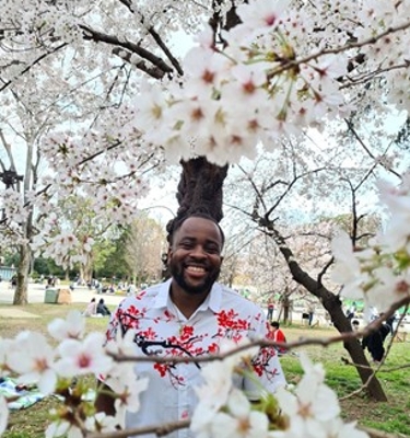 Joe standing among the cherry blossoms in Japan